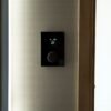 A modern black thermostat mounted on a wall.